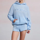 Light blue hoodie and shorts set with embroidered design on a plain background